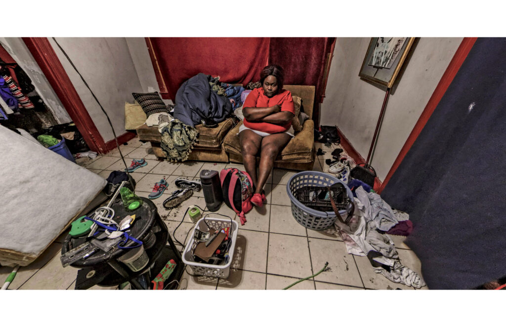 Cluttered room with household belongings, furniture, and personal items filling the interior.